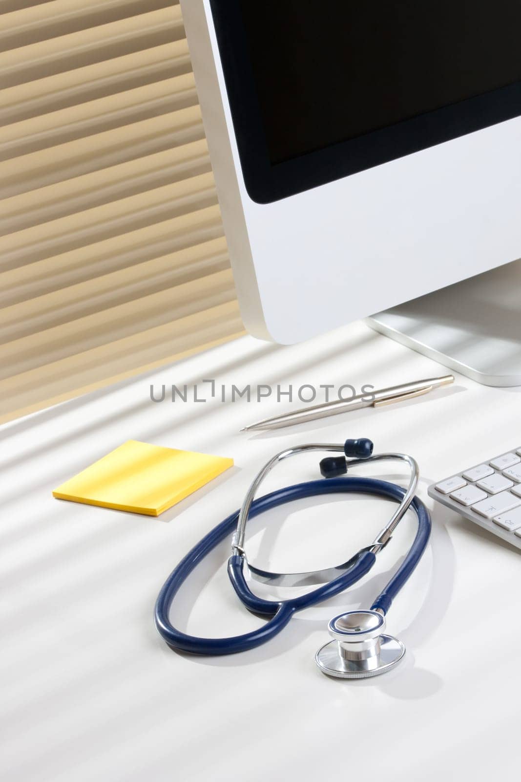 Doctor workplace with computer, stethoscope and office supplies