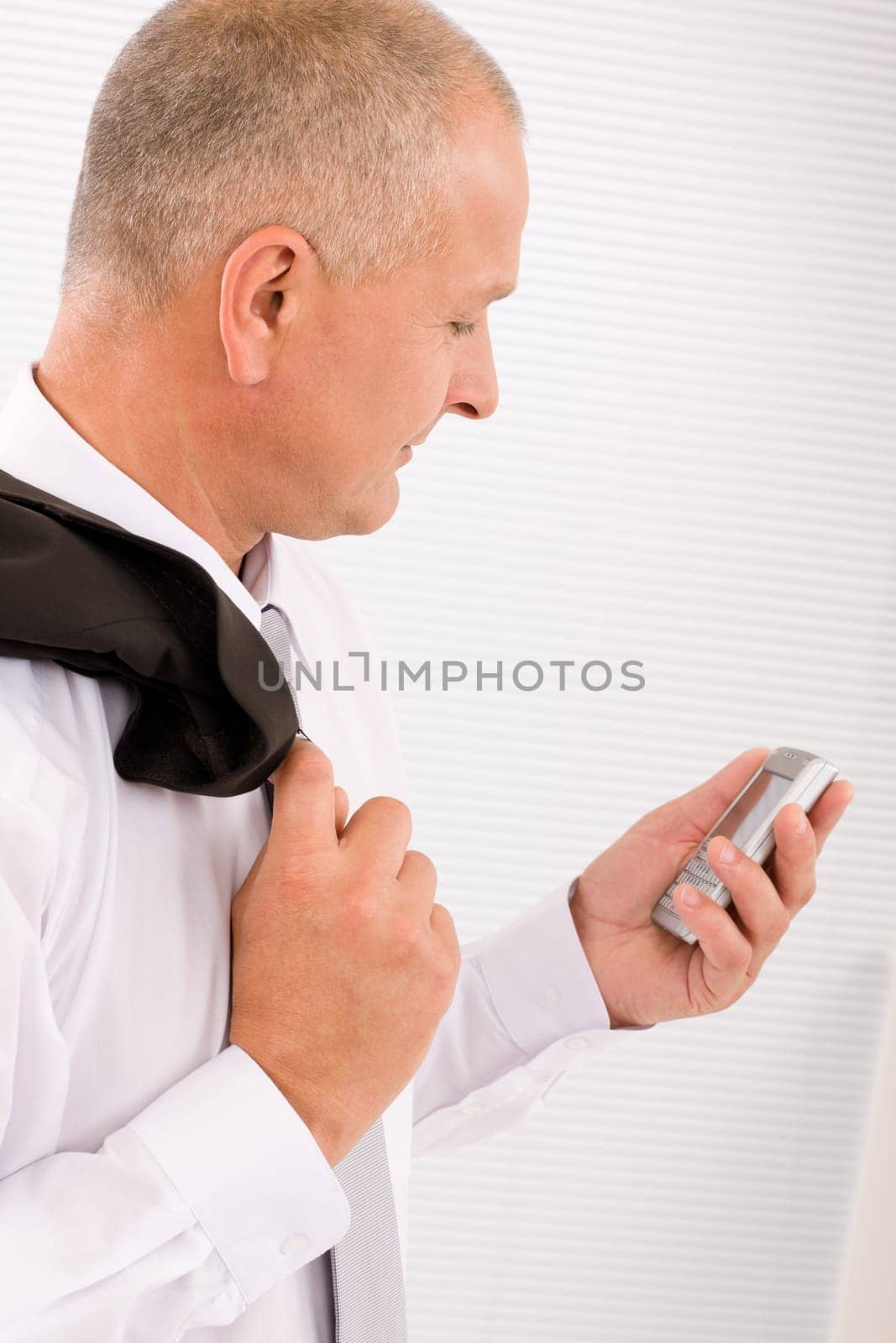 Mature handsome businessman wear suit looking at phone close-up portrait