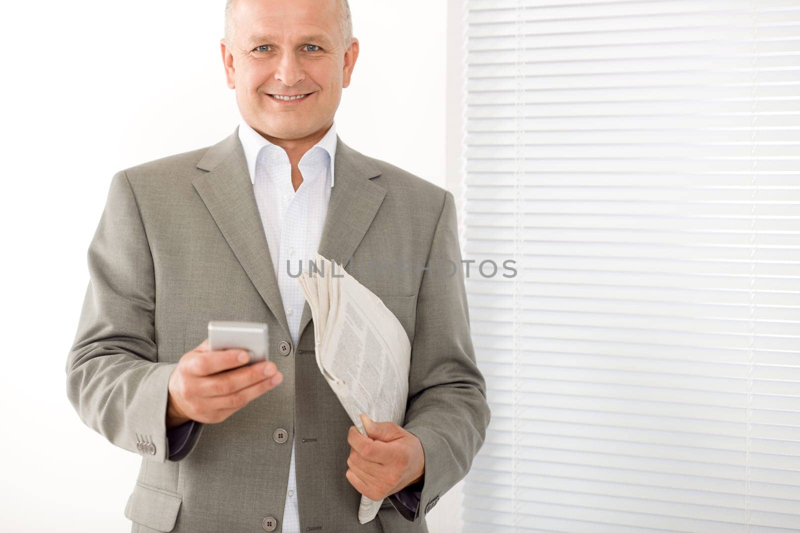 Handsome mature businessman smiling holding phone close-up professional portrait