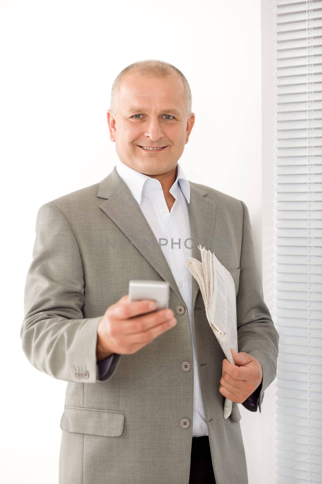Handsome mature businessman smiling holding phone close-up professional portrait