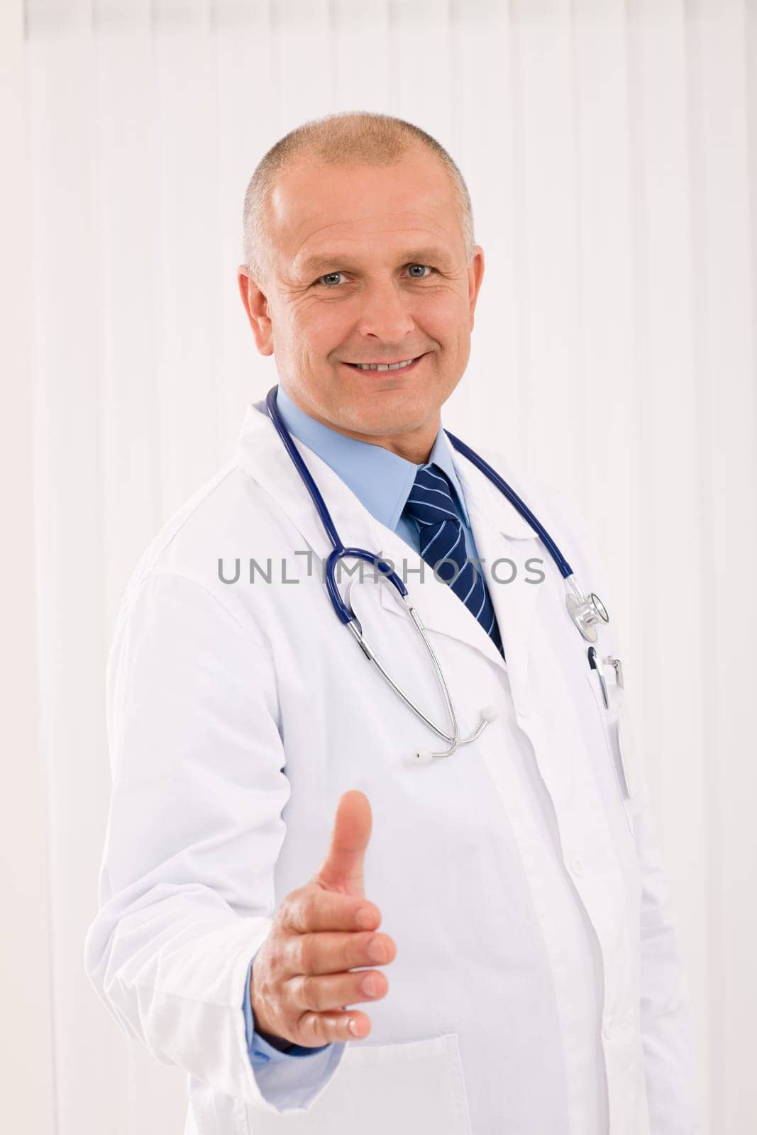 Happy mature doctor male giving handshake welcoming portrait