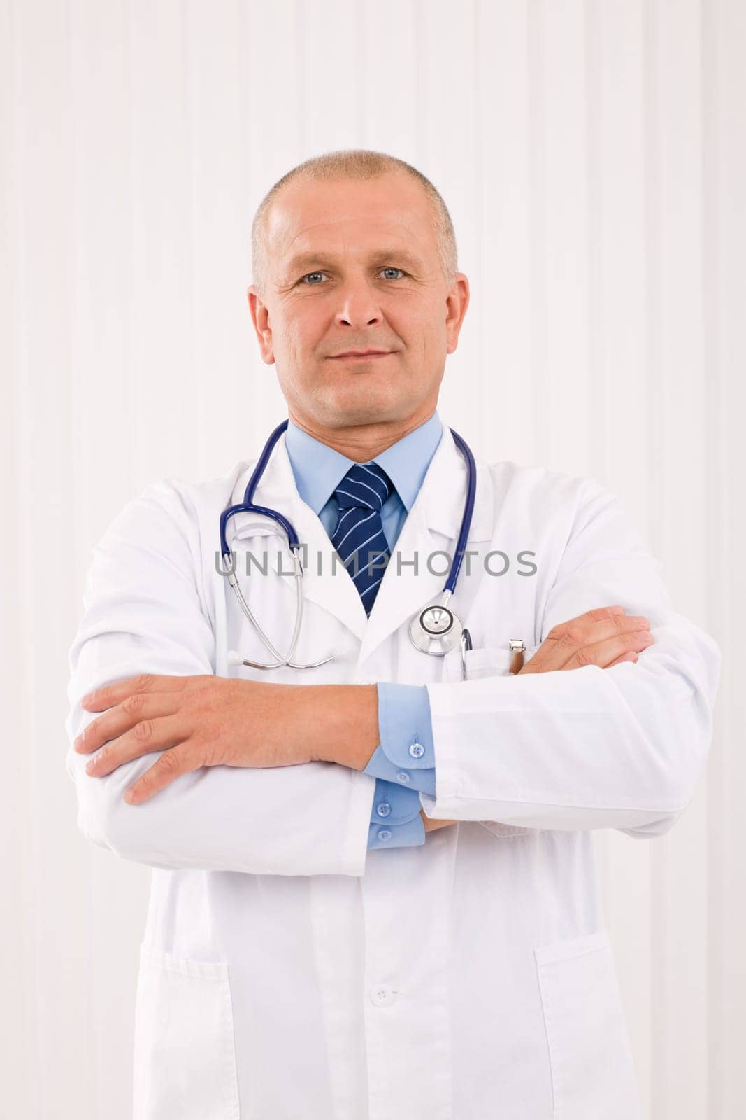 Portrait of mature professional doctor male with stethoscope crossed arms