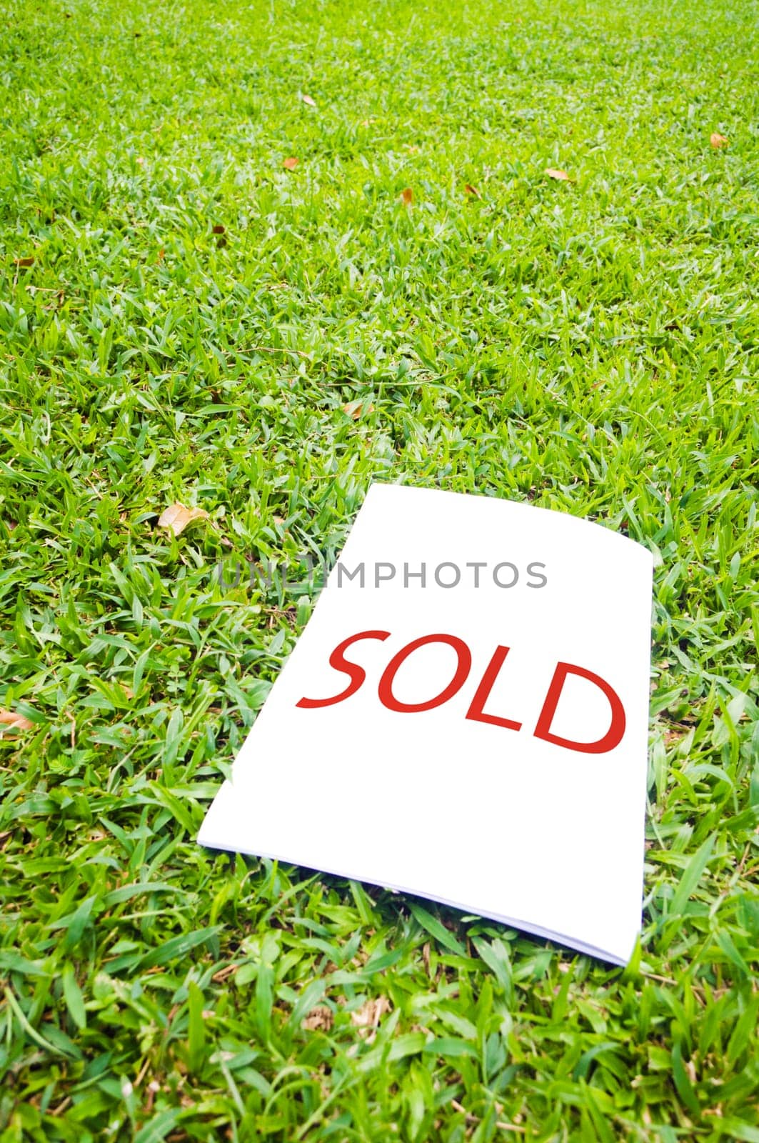 a sold sign on grass field. For real estate background.
