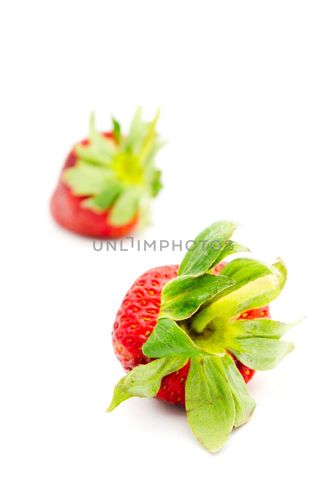 single isolated strawberry with other strawberries in the background.