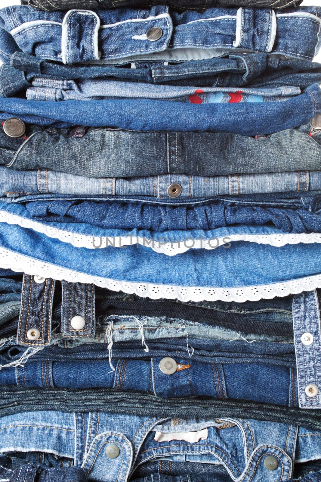 Close-up to huge pile of female and male jeans clothes.