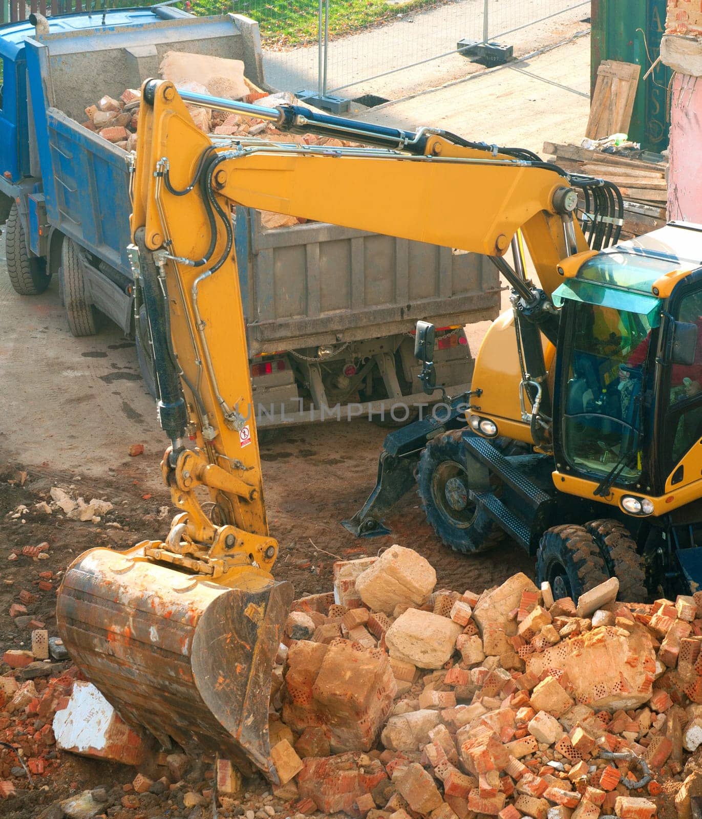 Digger and Truckload of Rubble in House Under Demolition