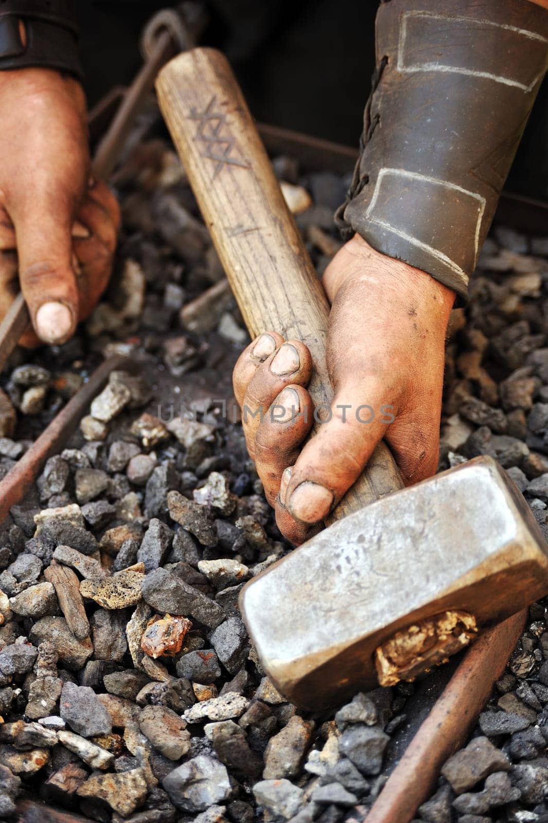 Detail of dirty hands holding hammer - blacksmith