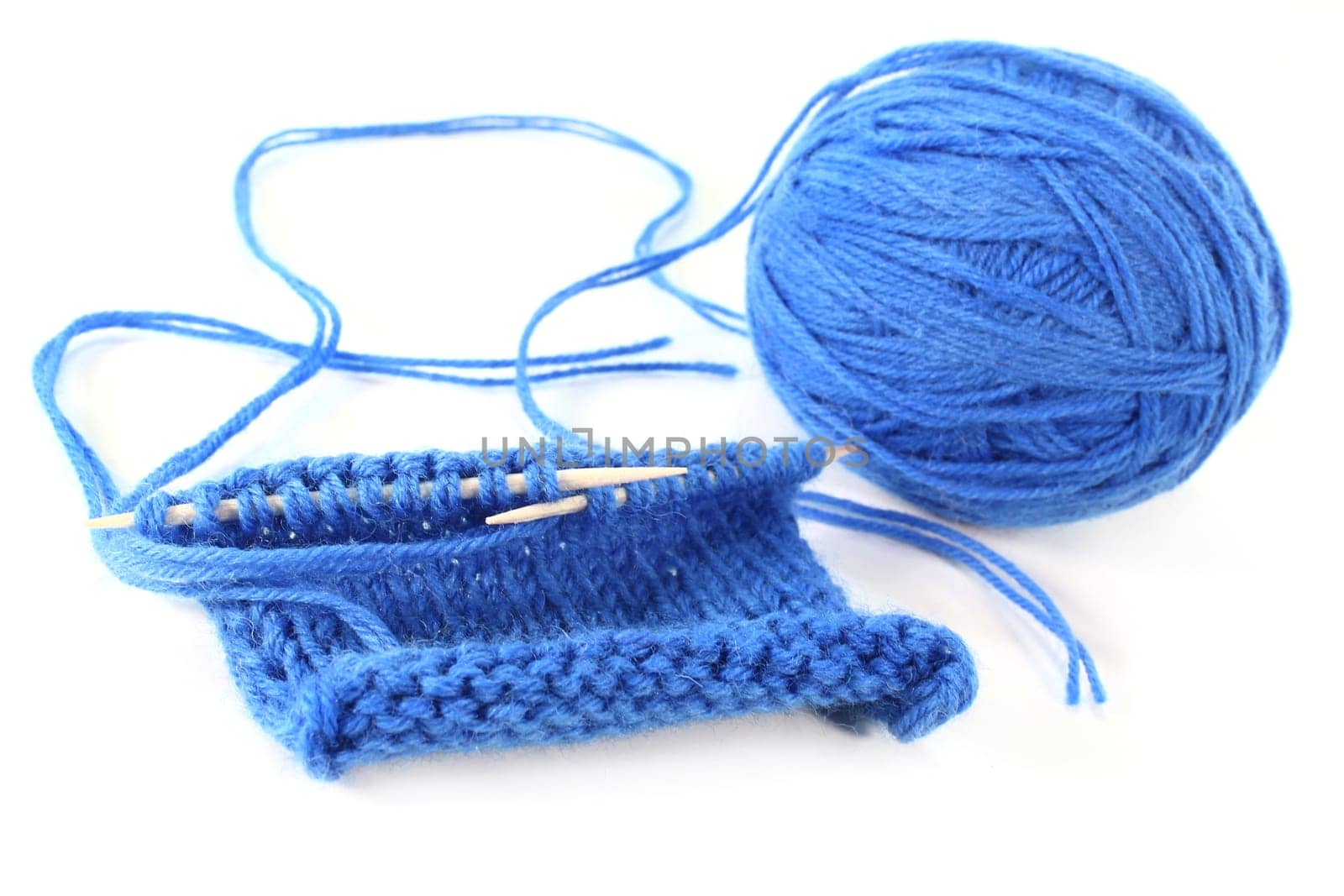 a blue ball of wool with a knitting sample