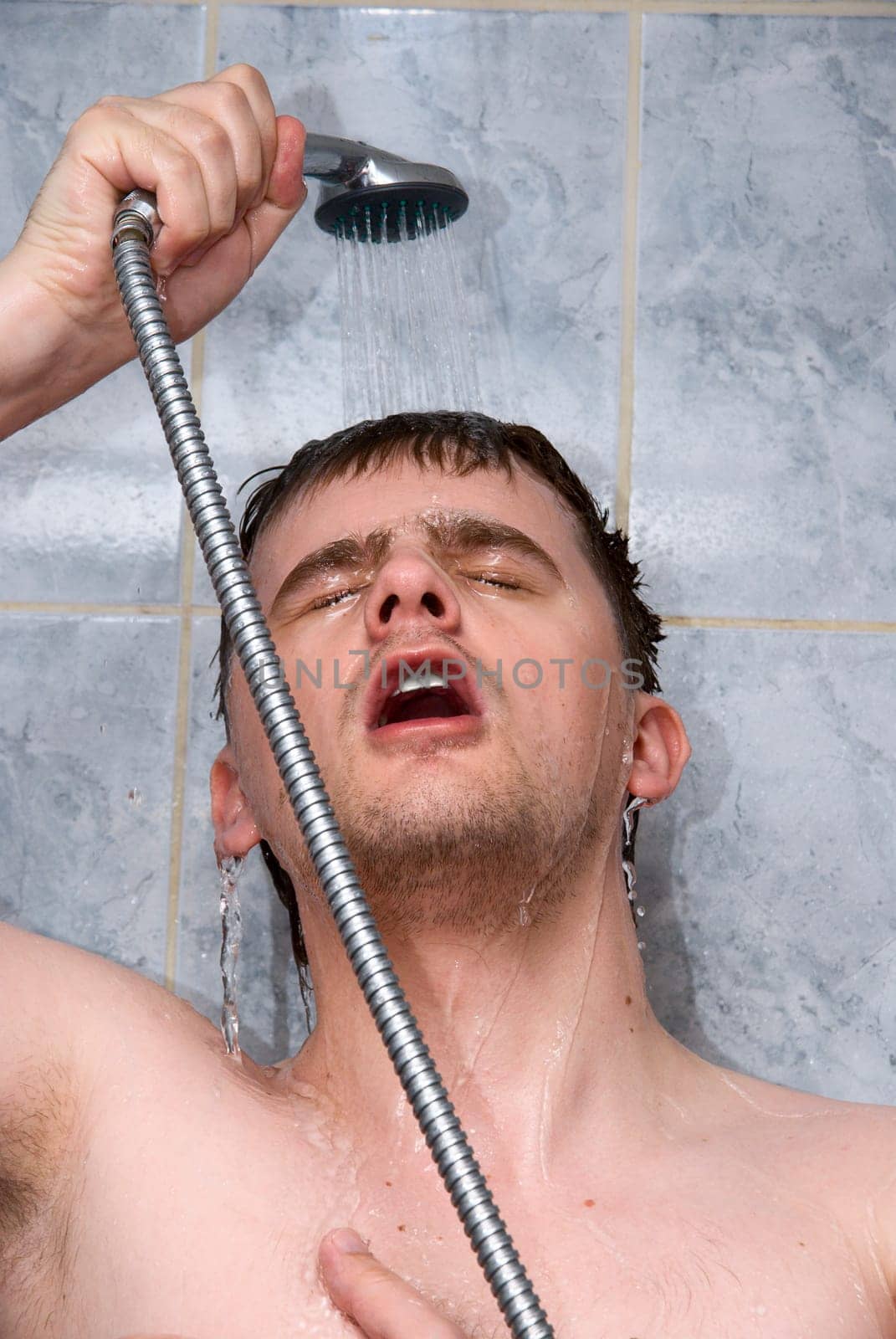 Young handsome man in a shower