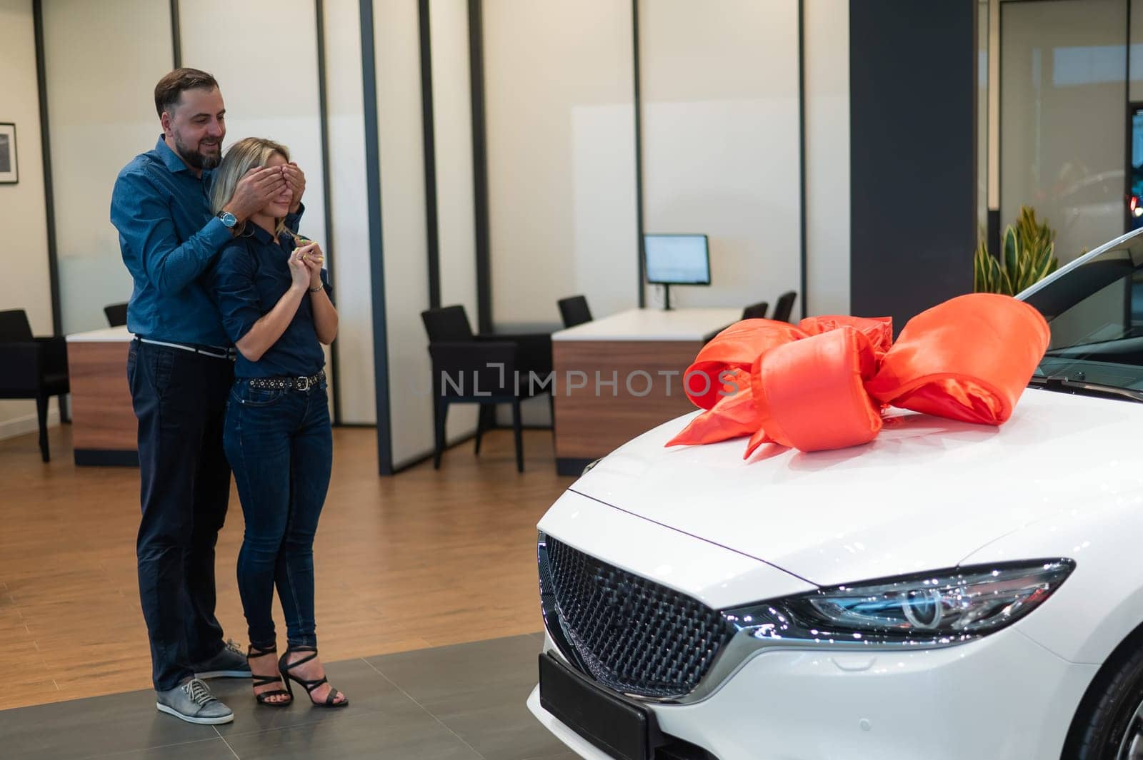 A bearded man makes a gift to his beloved wife in the form of a new white car. by mrwed54