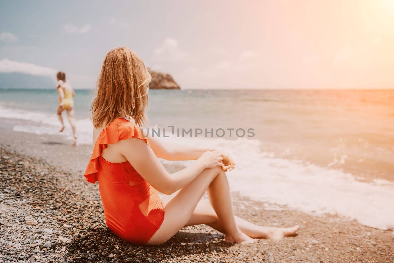 Happy loving family mother and daughter having fun together on the beach. Mum playing with her kid in holiday vacation next to the ocean - Family lifestyle and love concept.