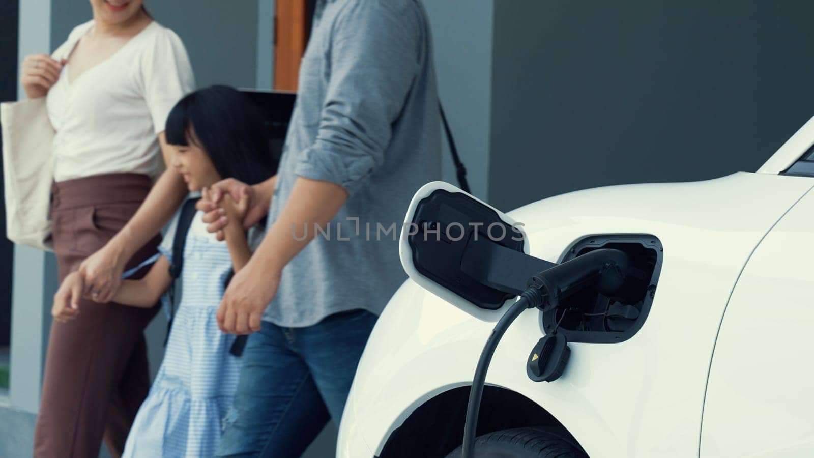 Progressive parent have returned from picking up daughter at school with EV car. by biancoblue