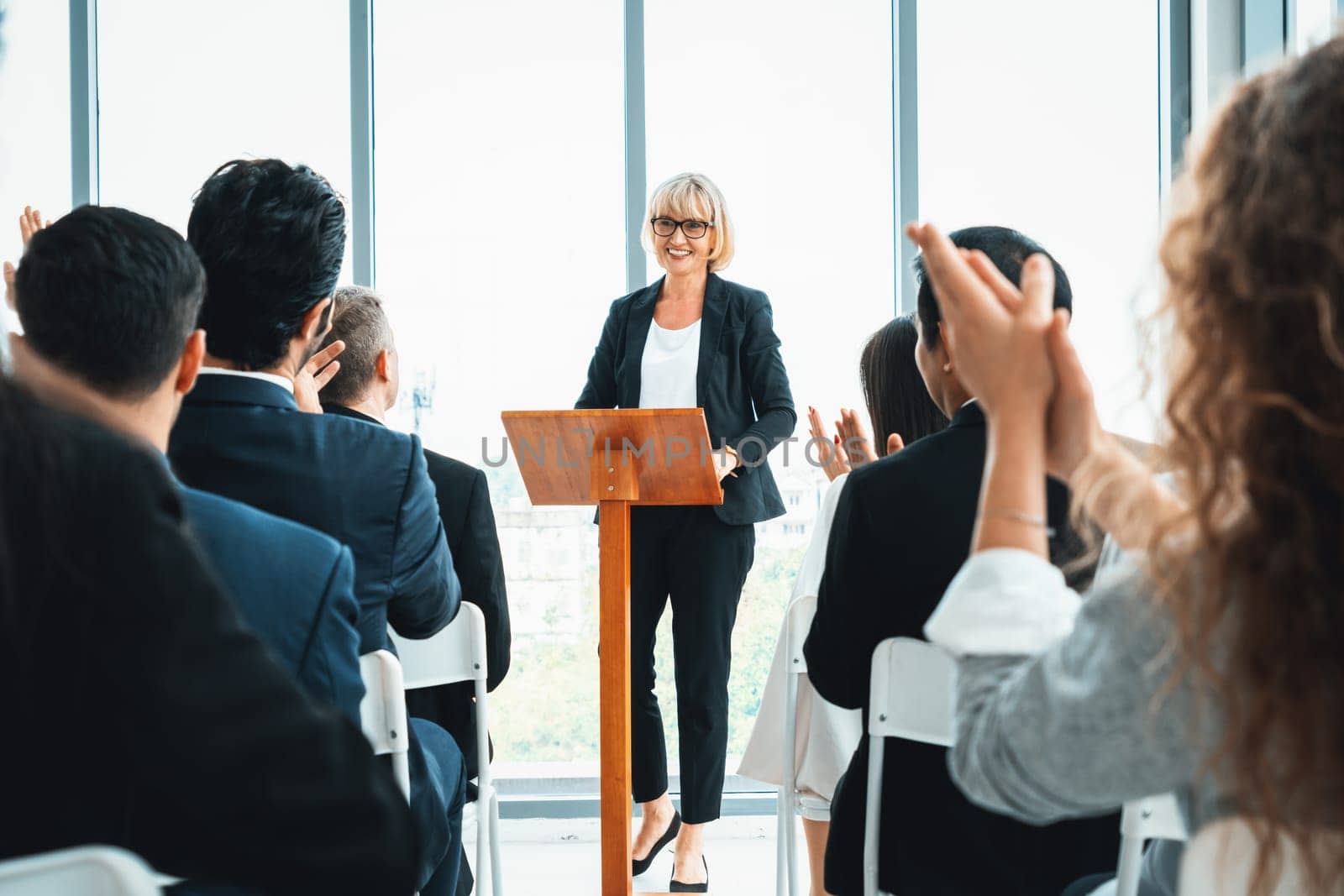 Group of business people meeting in a seminar conference . Audience listening to instructor in employee education training session . Office worker community summit forum with expert speaker . Jivy