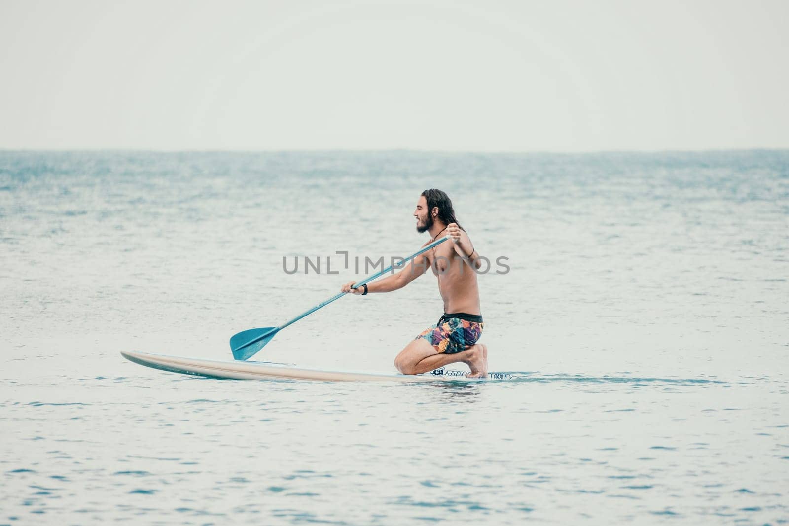 Sea woman and man on sup. Silhouette of happy young woman and man, surfing on SUP board, confident paddling through water surface. Idyllic sunset. Active lifestyle at sea or river. by panophotograph