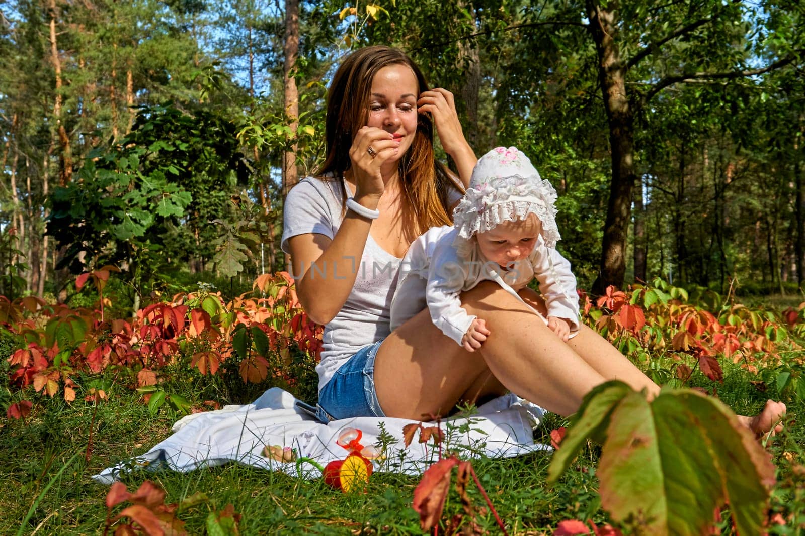 Young happy mother with a cute breast newborn baby in a sunny forest by jovani68