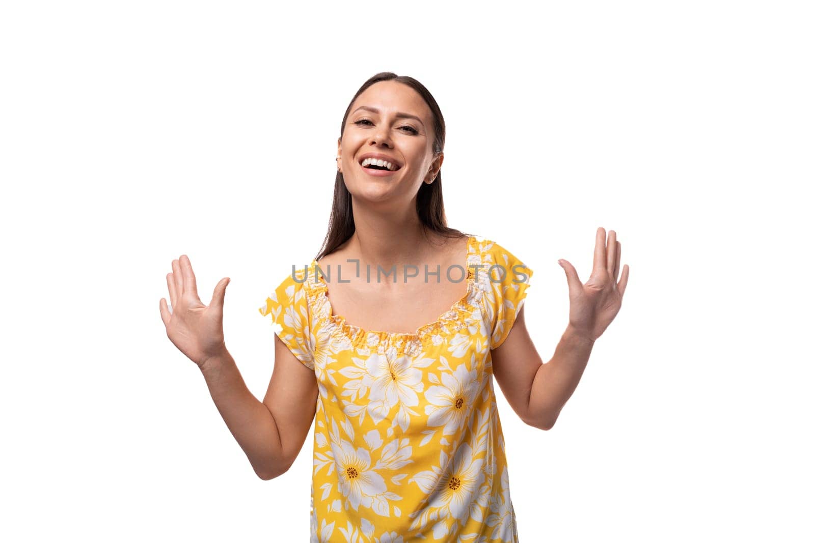 Caucasian young woman with straight black hair smiles welcomingly on a white background by TRMK