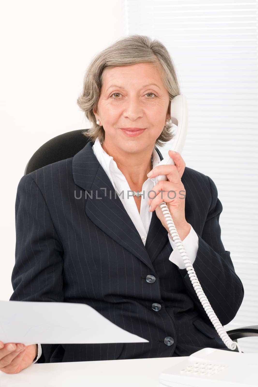 Senior professional businesswoman on phone hold empty sheet