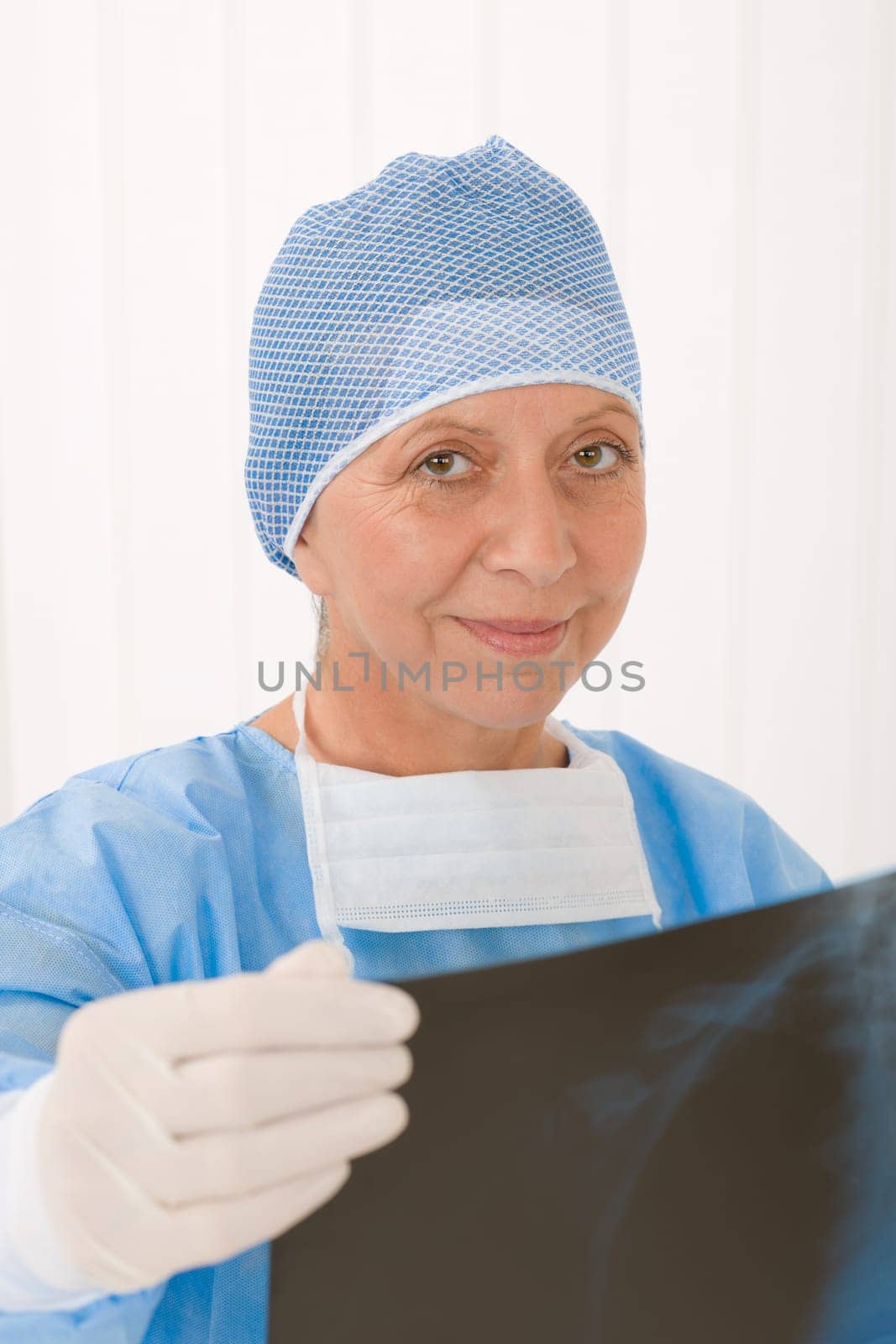 Senior surgeon female in protective operation overall uniform and mask