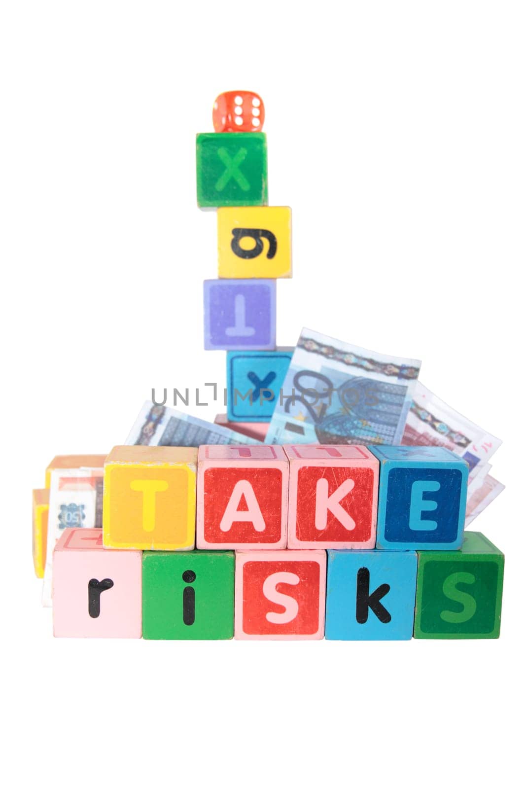 assorted childrens toy letter building blocks against a white background that spell take risks
