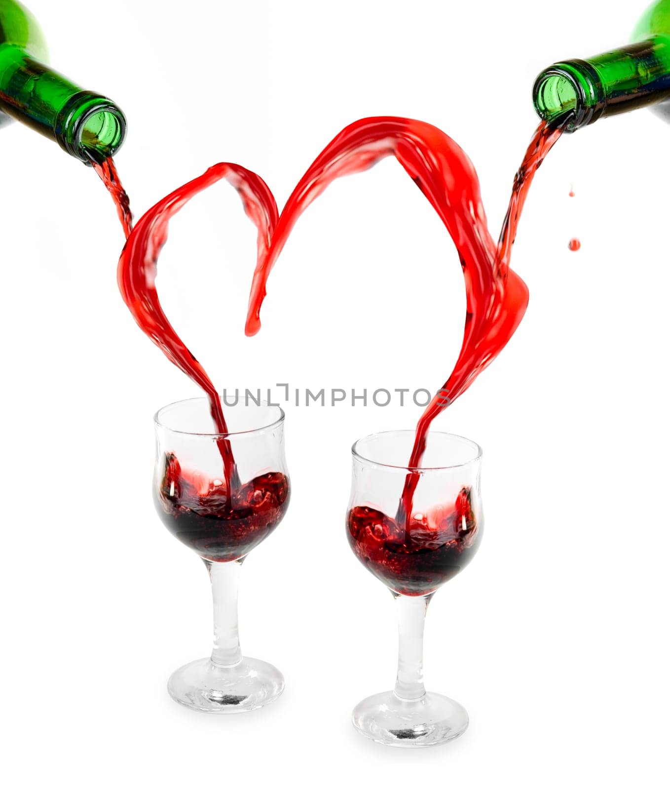 Heart from pouring red wine in goblets isolated on white