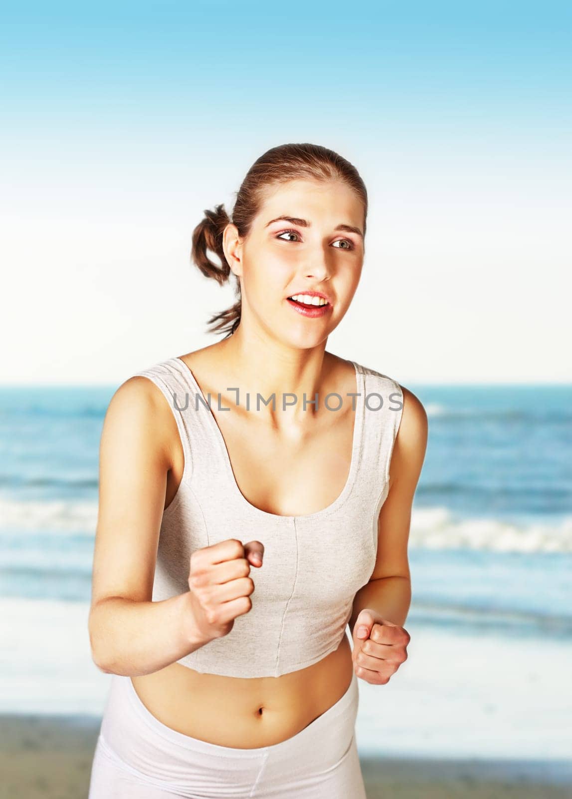 Pretty young woman jogging on the beach