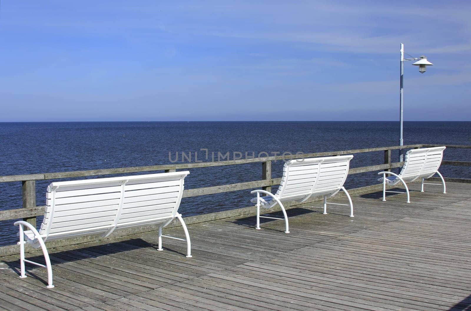 White benches on the pier of the seaside resort of Bansin,Usedom Island,Mecklenburg-Western Pomerania,Germany
