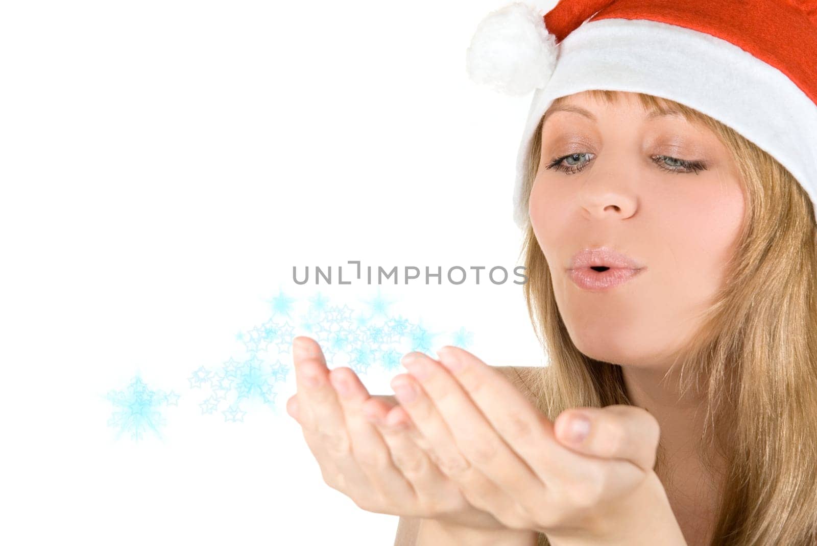 Beautiful santa girl blowing to snowflakes at her hands isolated on white background