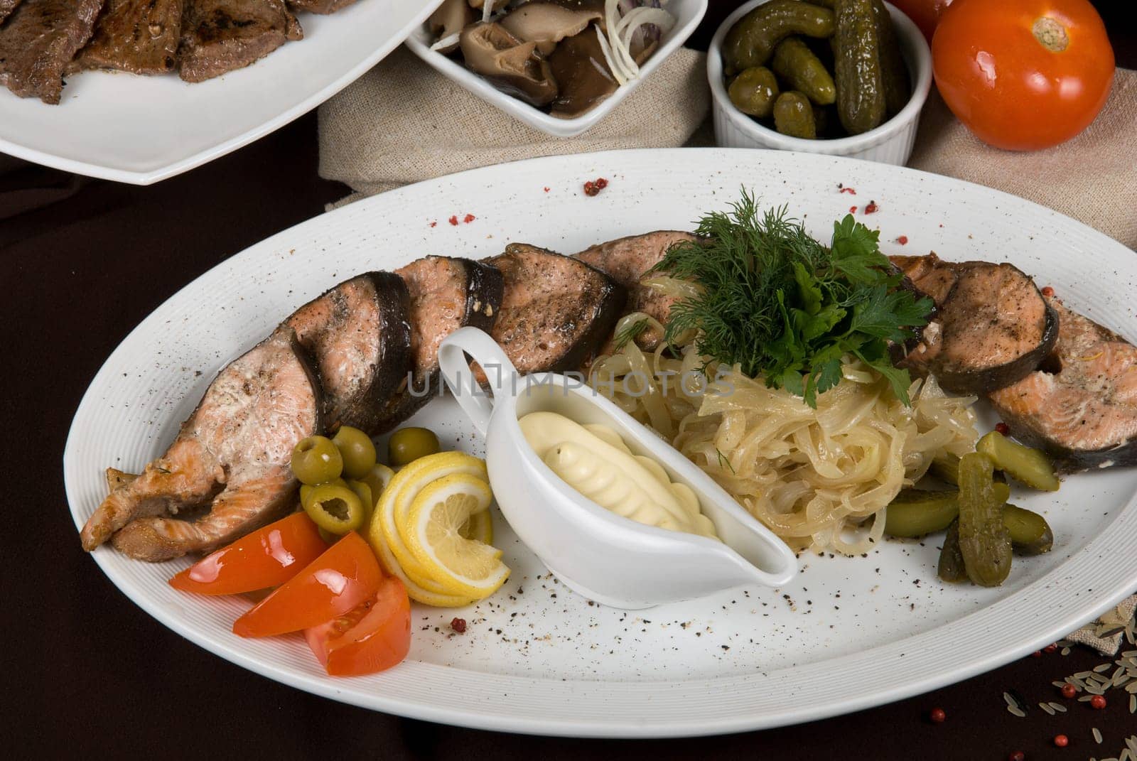 Many food dishes on the table. Fish dish close up.