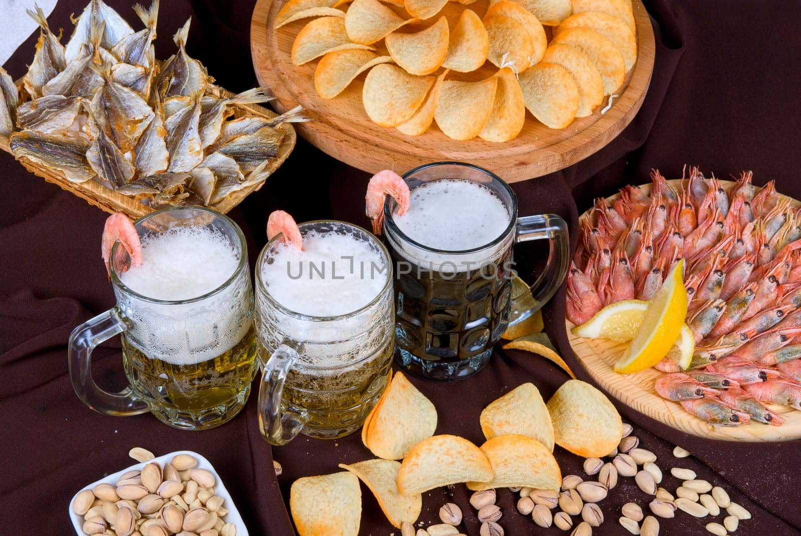 Beer and snacks set: chips, pistachio, shrimp and fish