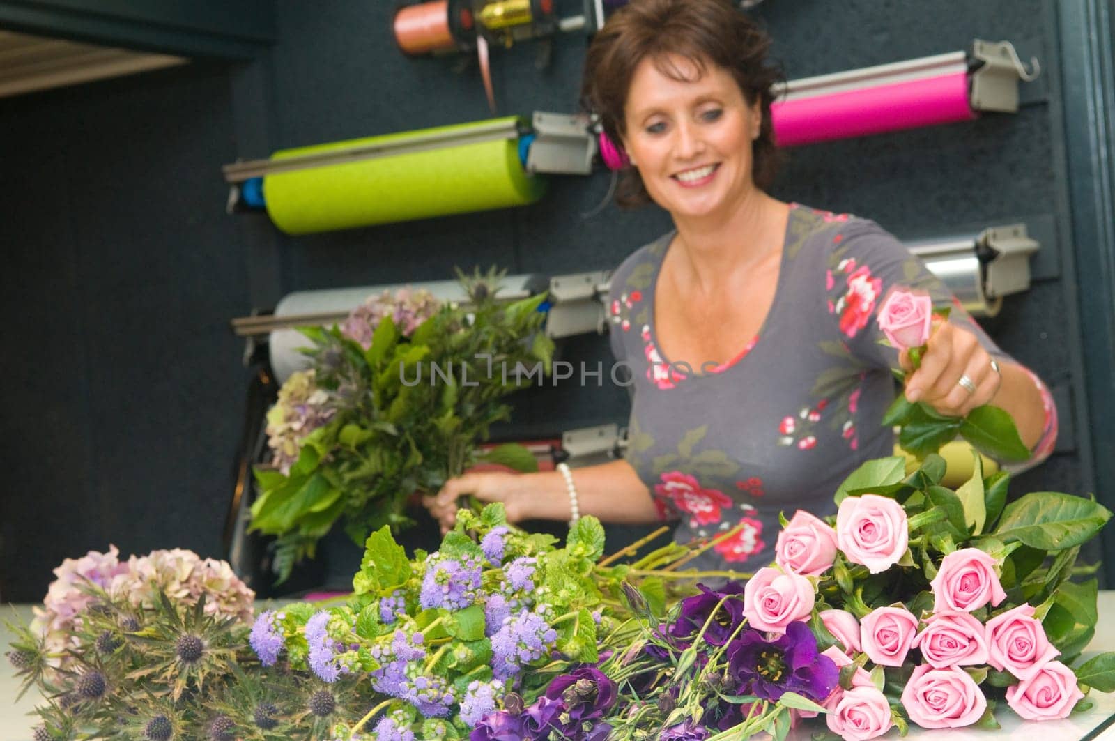 Female florist working in a flower store, making the bouquet ready for the customer