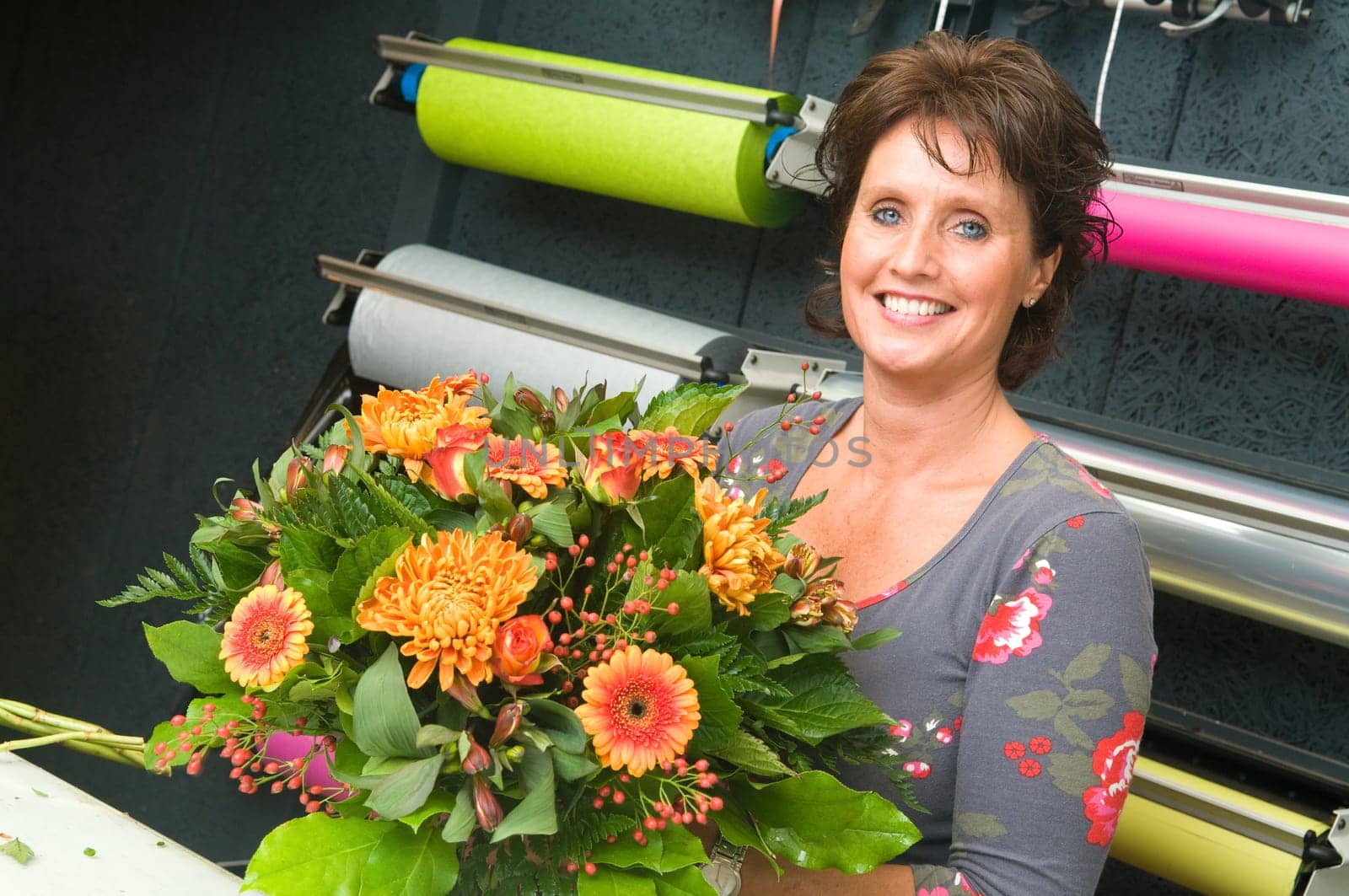 Female florist working in a flower store, making the bouquet ready for the customer