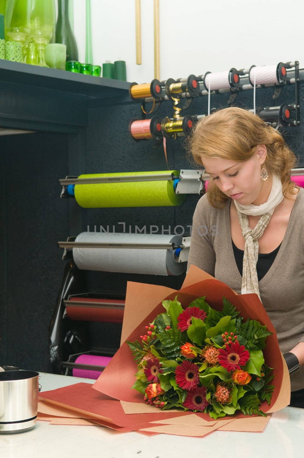 Female florist working in a flower store, making the bouquet ready for the customer