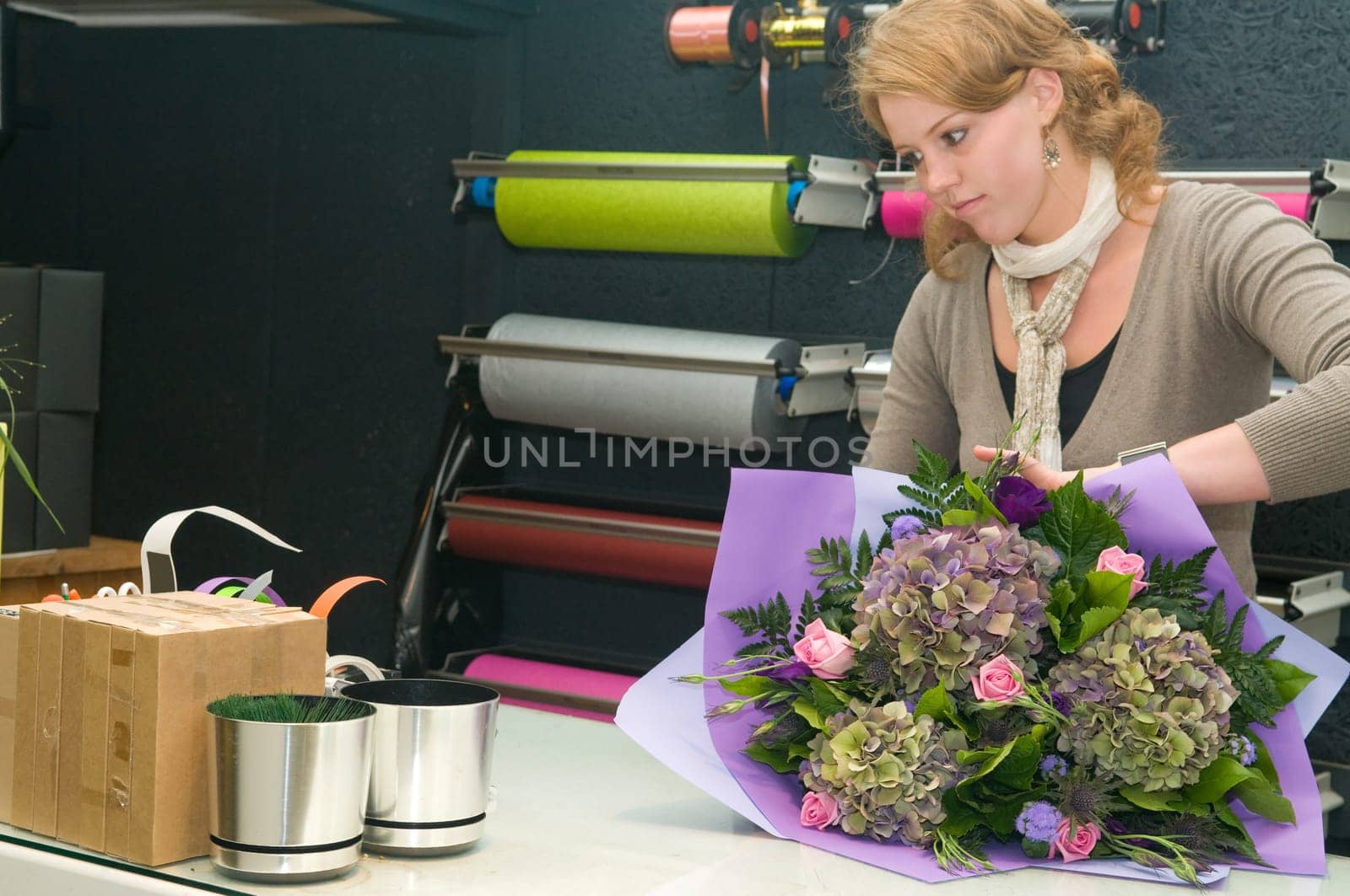 Female florist working in a flower store, making the bouquet ready for the customer