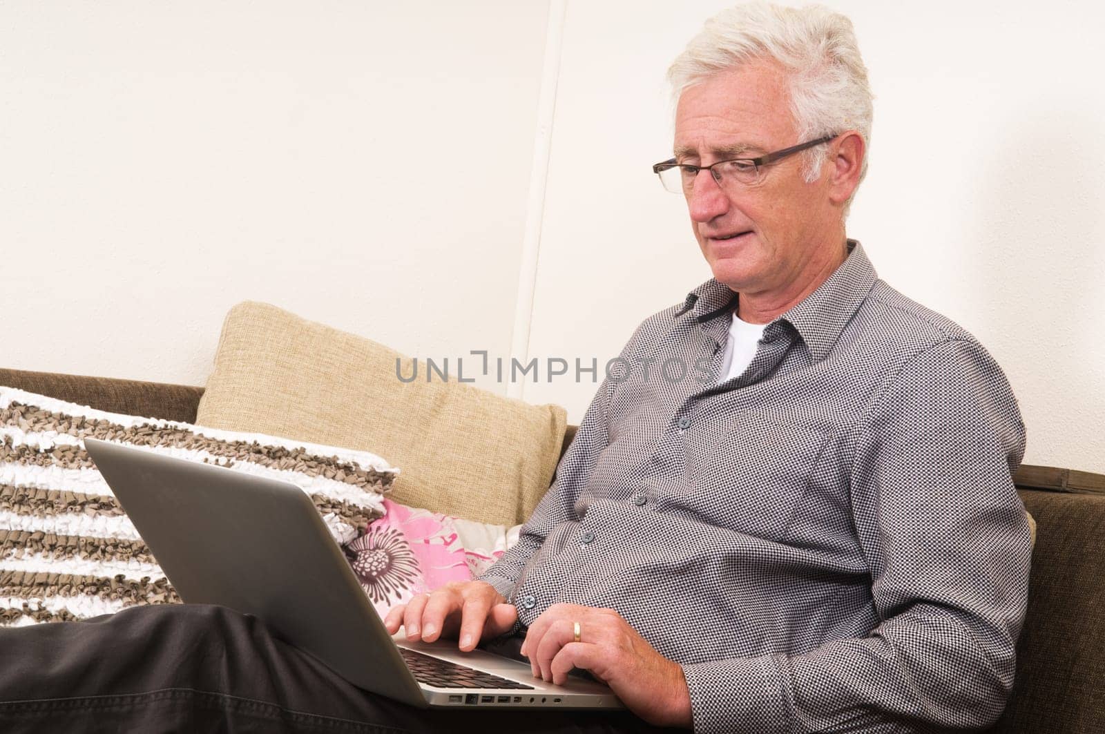 Senior working on a laptop while sitting on the couch
