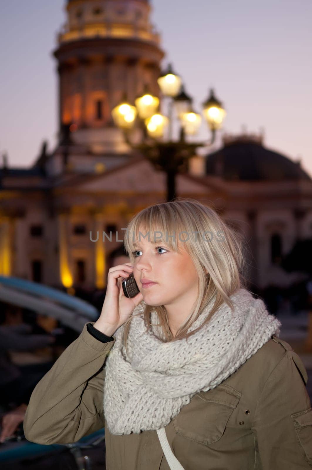 Young woman talking on the phone in the city in the evening