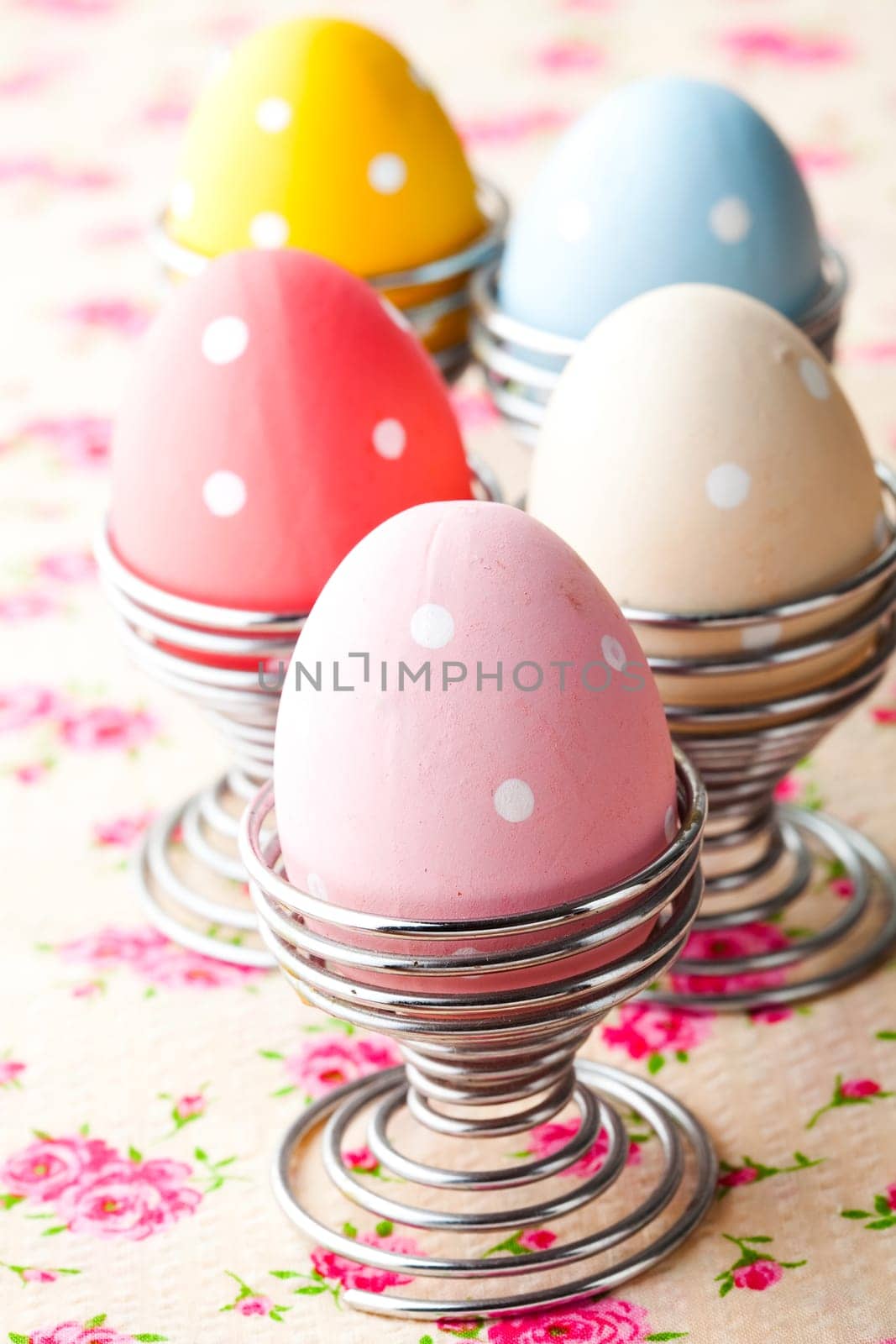 Close-up of pastel colored Easter eggs in metal holders