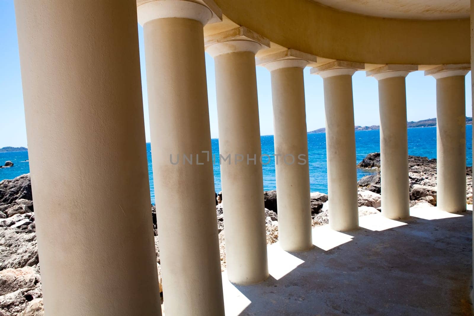 Lighthouse pillars with blue sea in the background in Argostoli, Kefalonia, Greece
