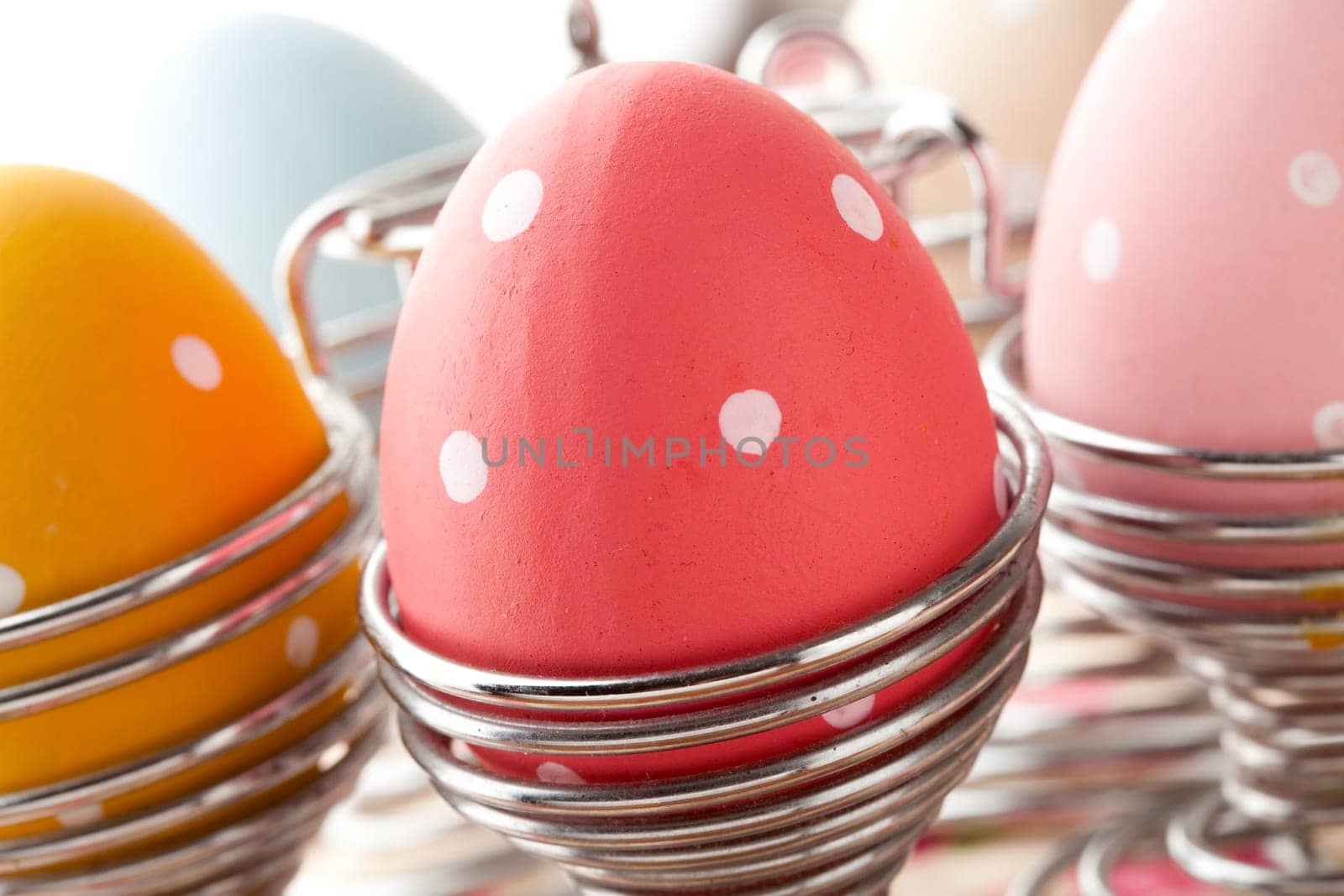 Close-up of pastel colored Easter eggs in metal holders