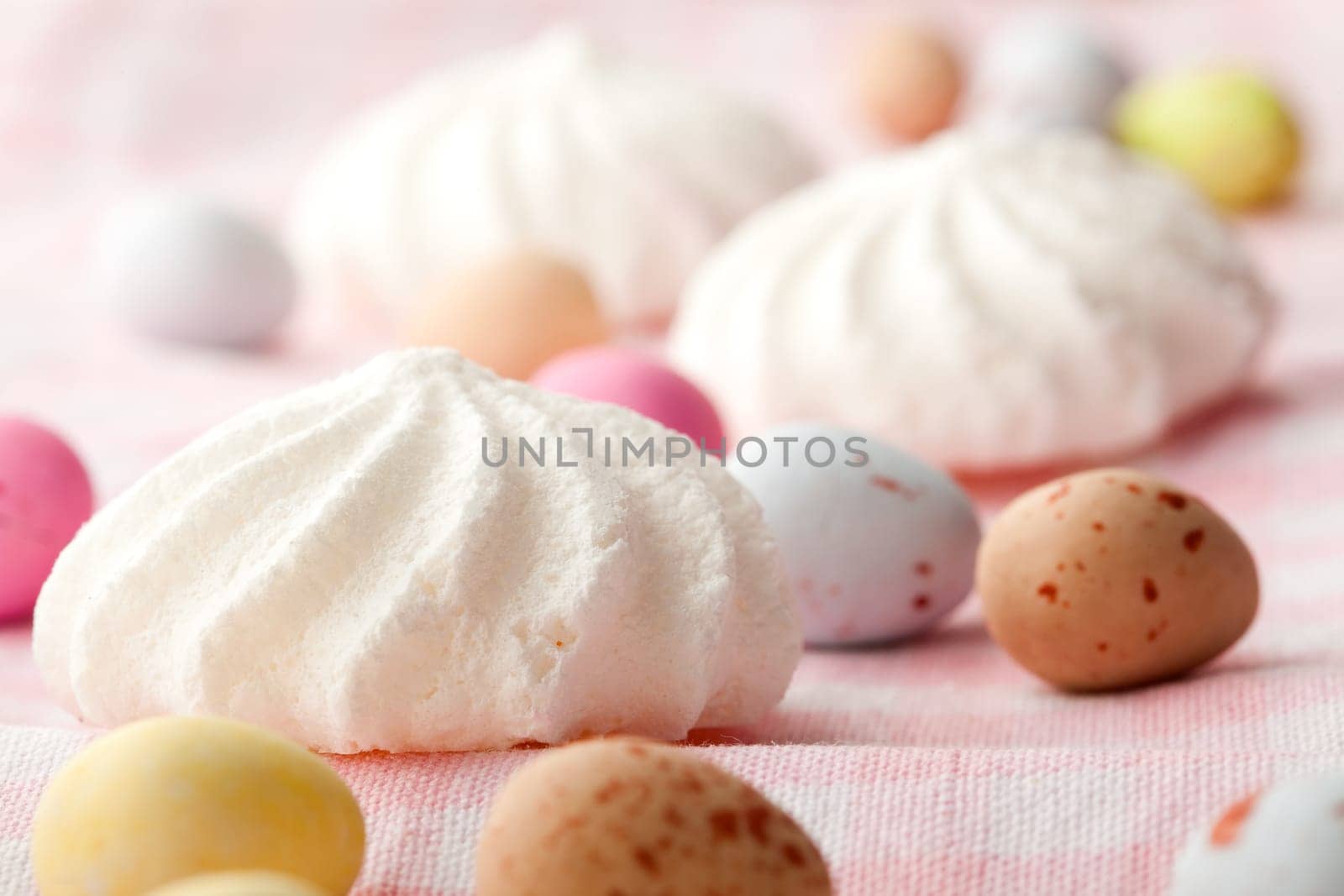 Close-up of pastel colored chocolate Easter egg candy with white meringue