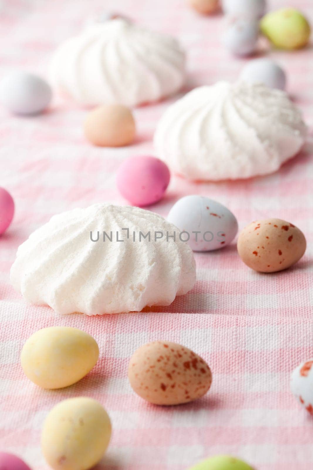 Close-up of pastel colored chocolate Easter egg candy with white meringue