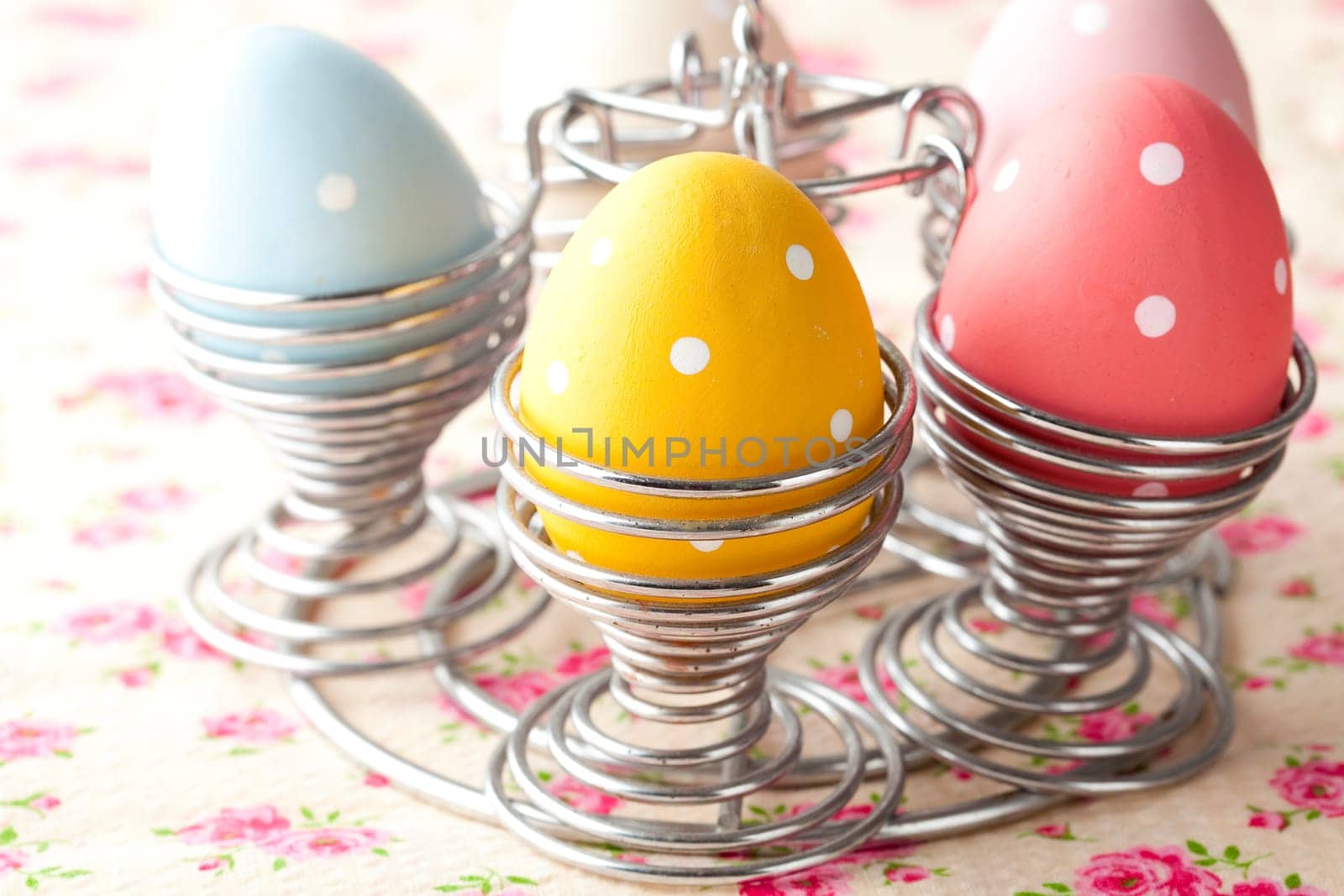 Close-up of pastel colored Easter eggs in metal holders