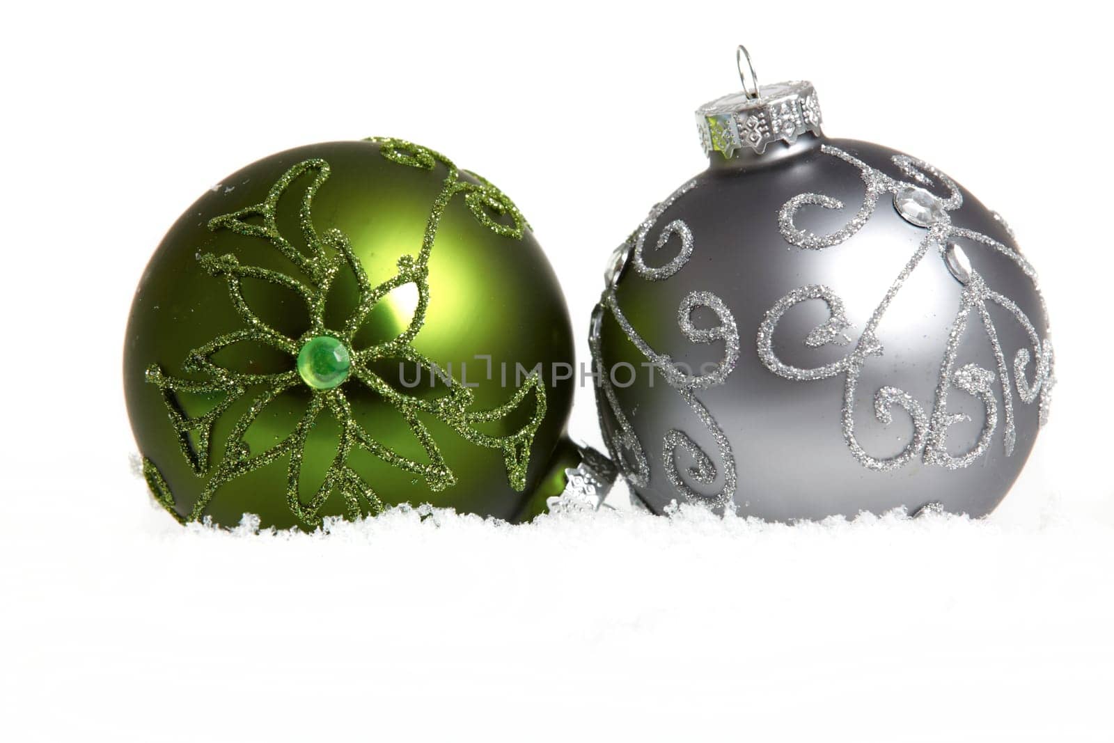 Two Christmas baubles in snow