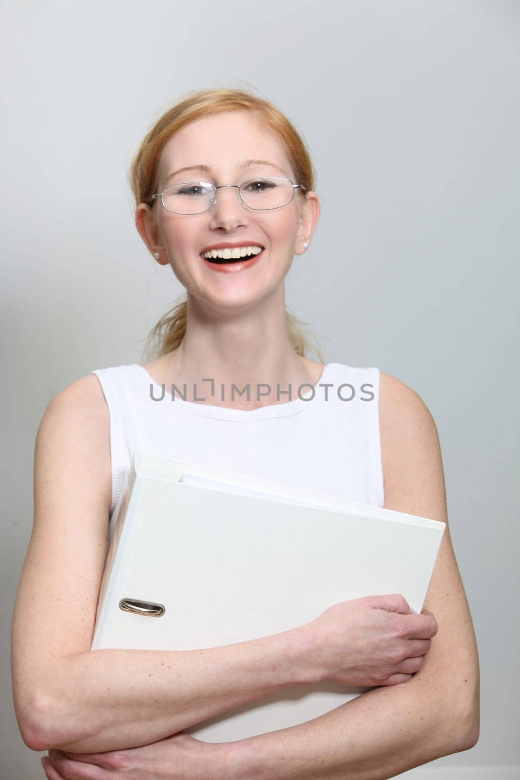 Laughing,young woman with glasses and file folder - portrait format
