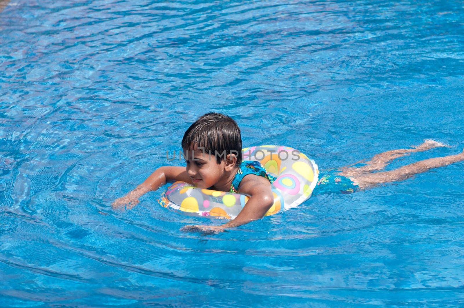 A handsome Indian kid playing in the pool