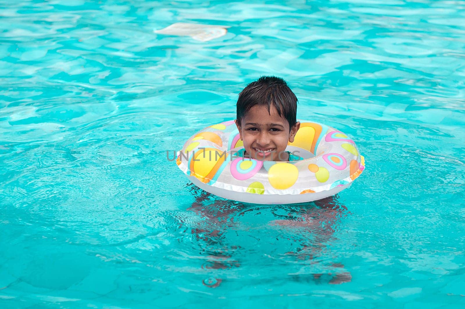 Handsome Indian kid playing in the pool