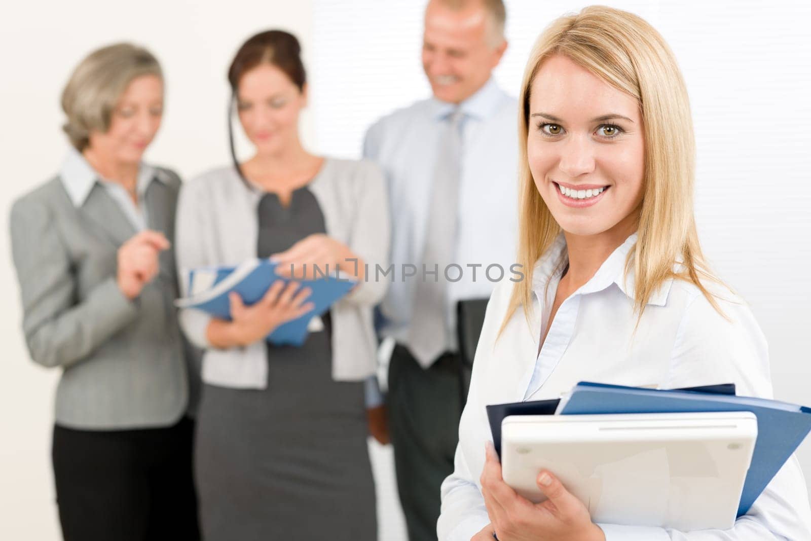 Business team attractive woman with happy colleagues discussing in back