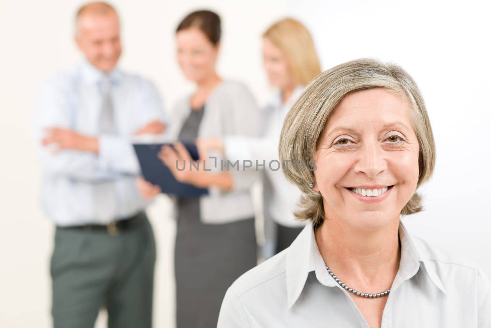Business team close-up of senior businesswoman with attractive happy colleagues