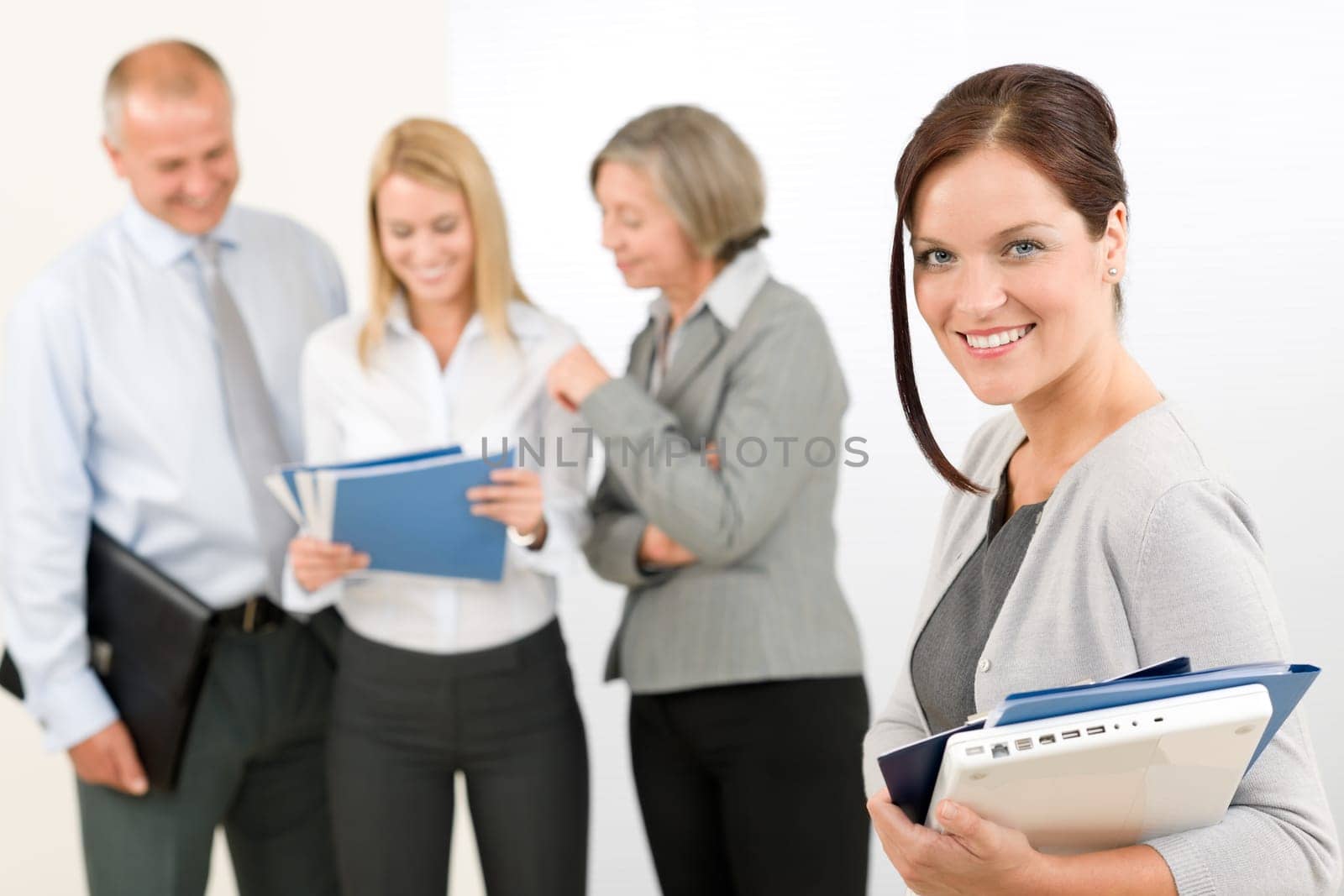 Business team attractive woman with happy colleagues discussing in back