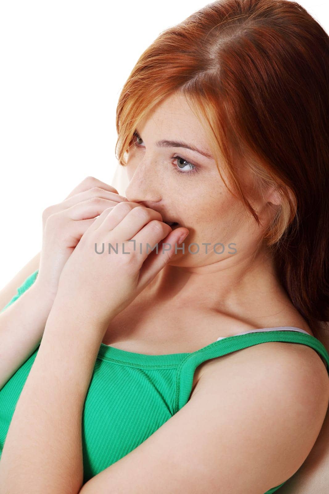 Young caucasian pretty frightened teen girl with hands on her mouth over white.