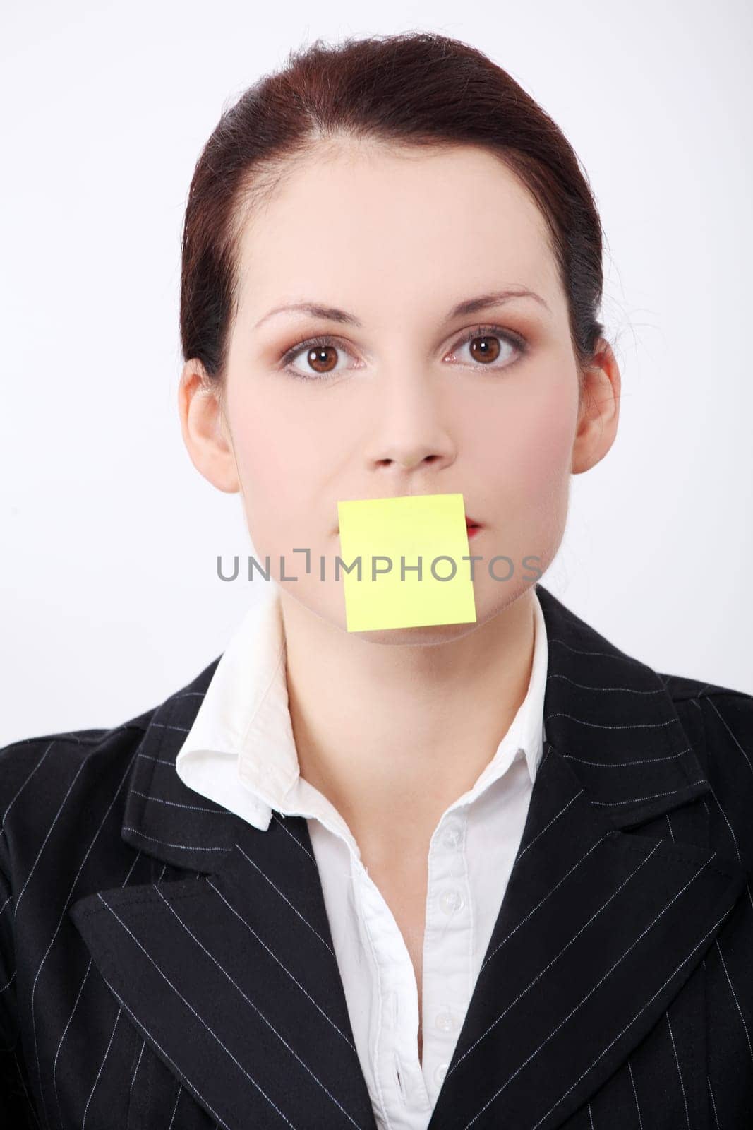 Pretty caucasian woman`s with post it note on her mouth closeup.